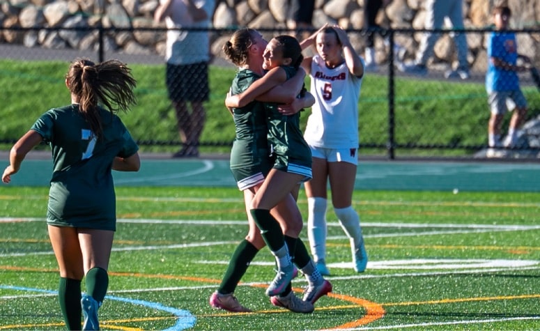 Michaela Poidomani (right) and Savannah Ryan (left) celebrate Poidomani's goal against Wellesley. (Patrick Donnelly/NESJ)